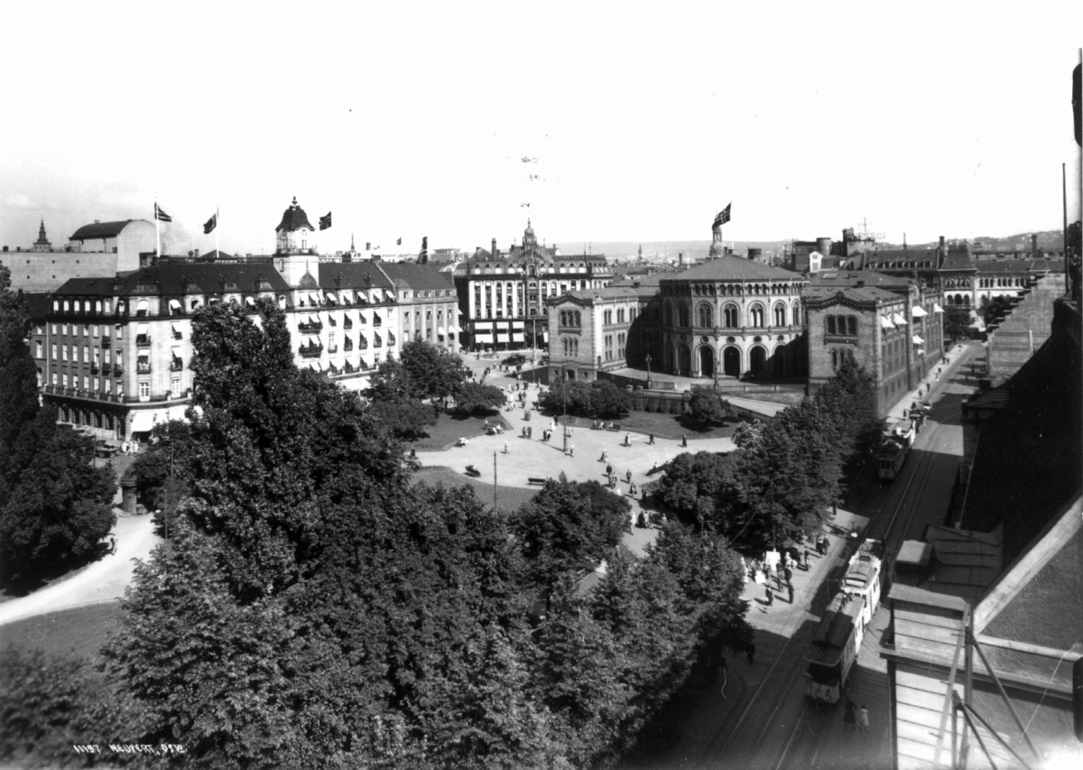 Utsikt over Grand Hotel og Stortinget, Oslo 1934.
Oversiktsbilde. Gater med trikker og fotgjengere.
