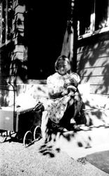 Jorunn Fossberg med dukker og dukkevogn foran sommerhus. Bil