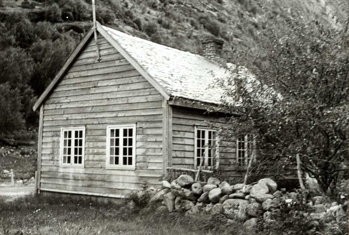 Ljøsne, Lærdal, Sogn og Fjordane, bygget 1866.  Lite grått skolehus med steingjerde og mot fjell. Registrering utført 1958-59 av Johan Schiong for Noregs Lærarlag. 