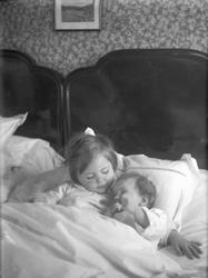Søstrene Guri og Siri Arentz ligger sammen i en seng. Fotogr