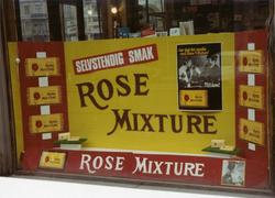 Vindusutstilling med reklame for Rose Mixture hos Majoren To