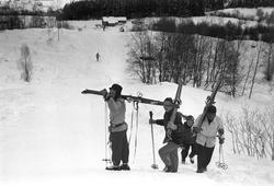 Publikum i løypa med ski på skuldrene. Holmenkollrennene på 