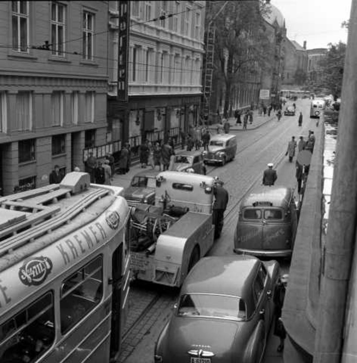 Oslo Sporveiers kranbil eller bergningsbil sleper en vogn av type MO (popuært kaldt "kylling") i Akersgata, Oslo 1956.