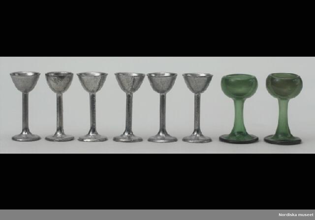 Inventering Sesam 1996-1999:
H 1,9 cm
2 st (a-b) remmar av grönt glas. Cuppa med dubbelt glas. Konformad fot med omvikt fotring.
Brukad av Catarina (född 1919) och Anne-Sophie (född 1921) von Heidenstam, döttrar till givaren.
Tillhör dockskåp 220.405 med inv nr 220.406-220.760
Leif Wallin okt 1997