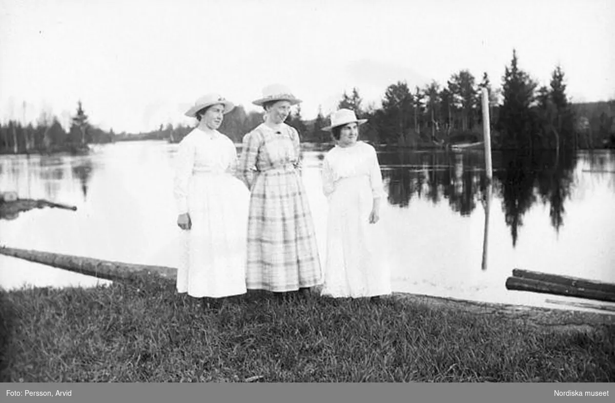 Helporträtt av tre kvinnor vid en sjö. Sörsjön, Transtrand sn, Dalarna.