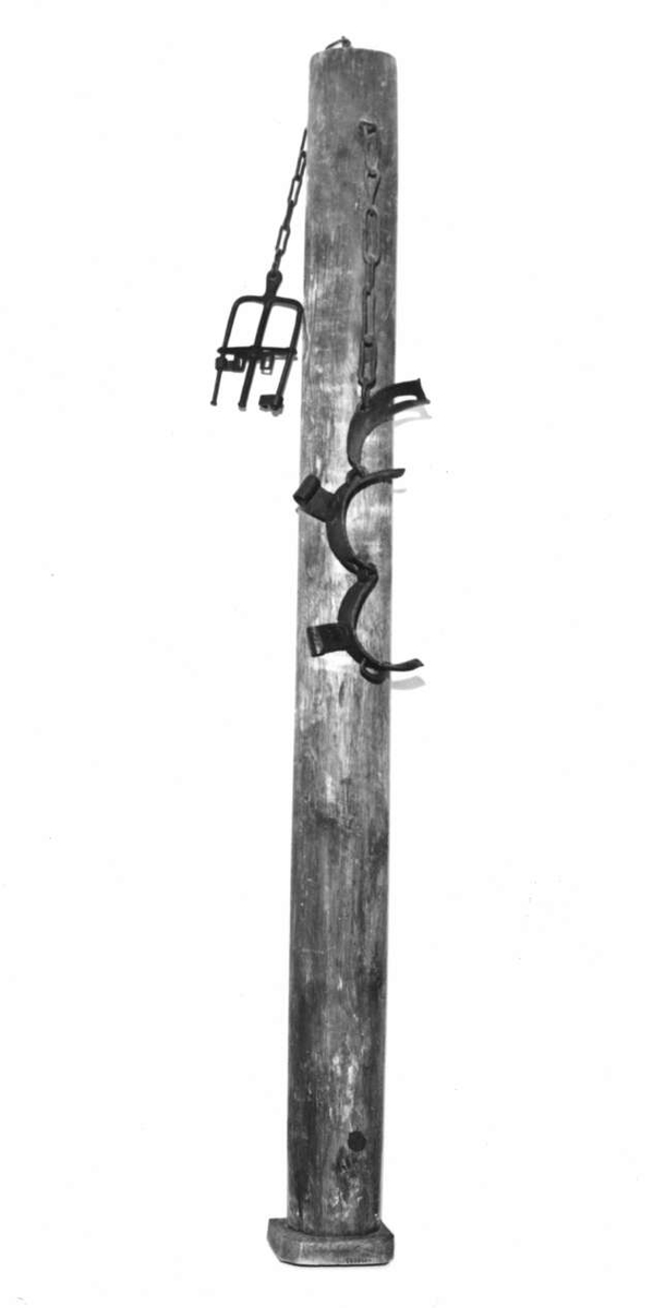 Straffstock med hälsjärn och handbojor. Stocken står på en fotplatta av trä. I dess topp är fästade ett halsjärn med låsanordning och gaffelformade handbojor med skruv. På halsjärnet stämplat årtalet: 1782.
