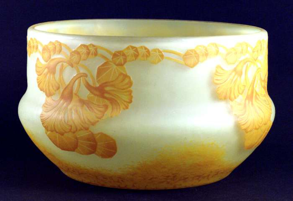 Skål av överfångsglas med orangefärgad dekor mot gul botten.
Signerad: Reijmyre N=328, A:E: Boman 1913 A Wallander, UNIK.

