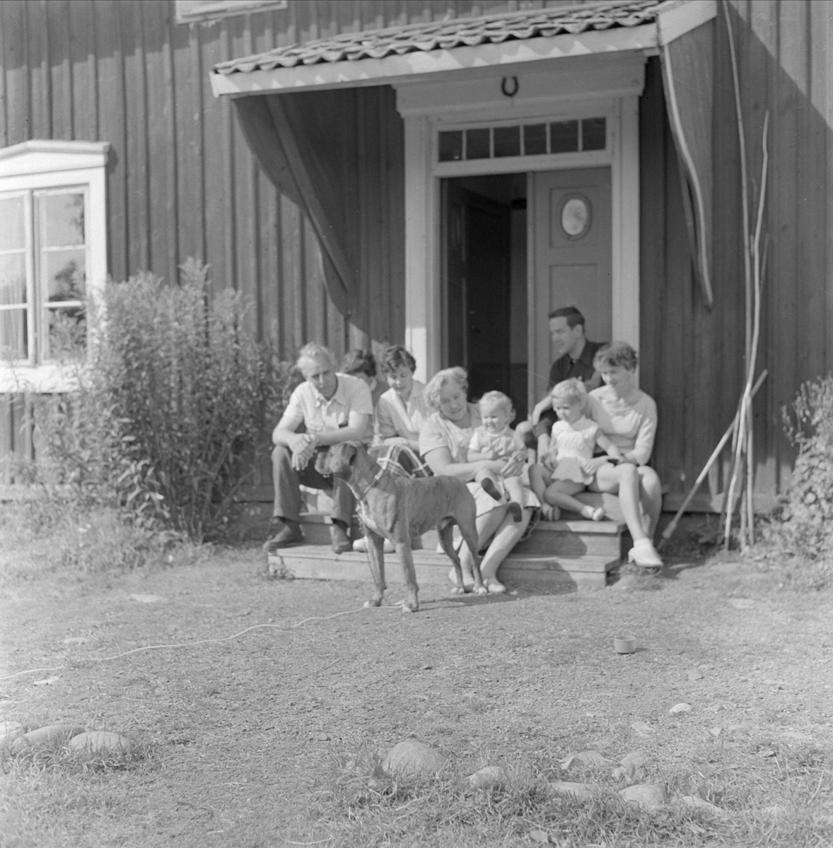 Gunnar Sundgrens familj på trappan utanför bostadshus, sannolikt Uppsala