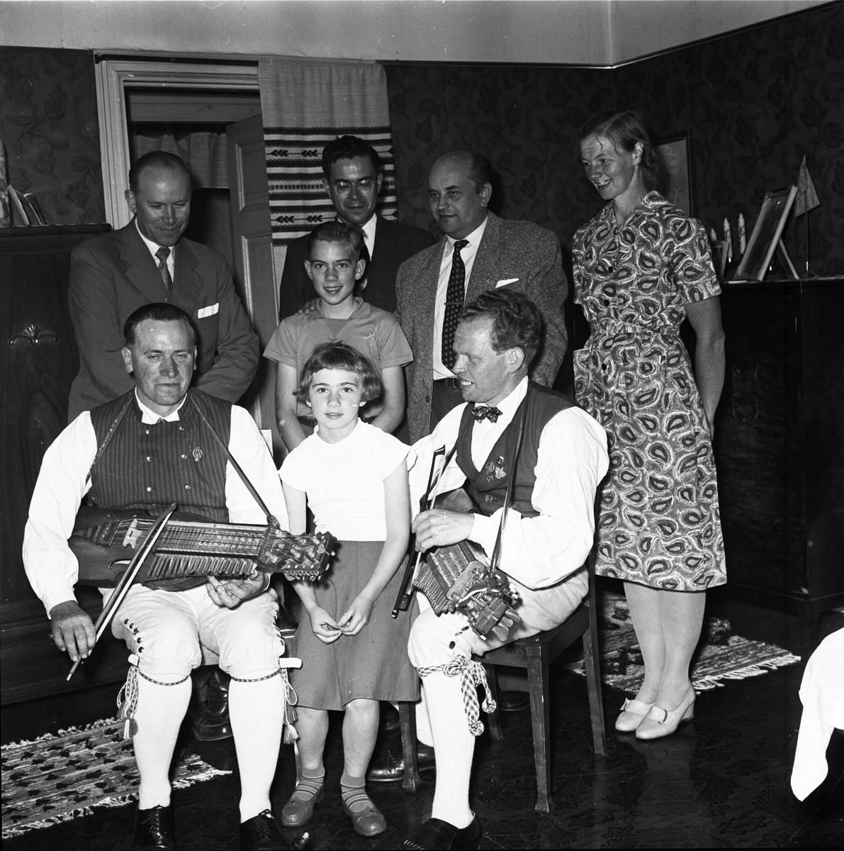 Spelmännen Eric Sahlström och Gösta Sandström, Sigbritt och Sigurd Sahlström, Erics hustru Anna Sahlström samt tre besökare i det Sahlströmska hemmet, Göksby, Tegelsmora socken, Uppland 1956