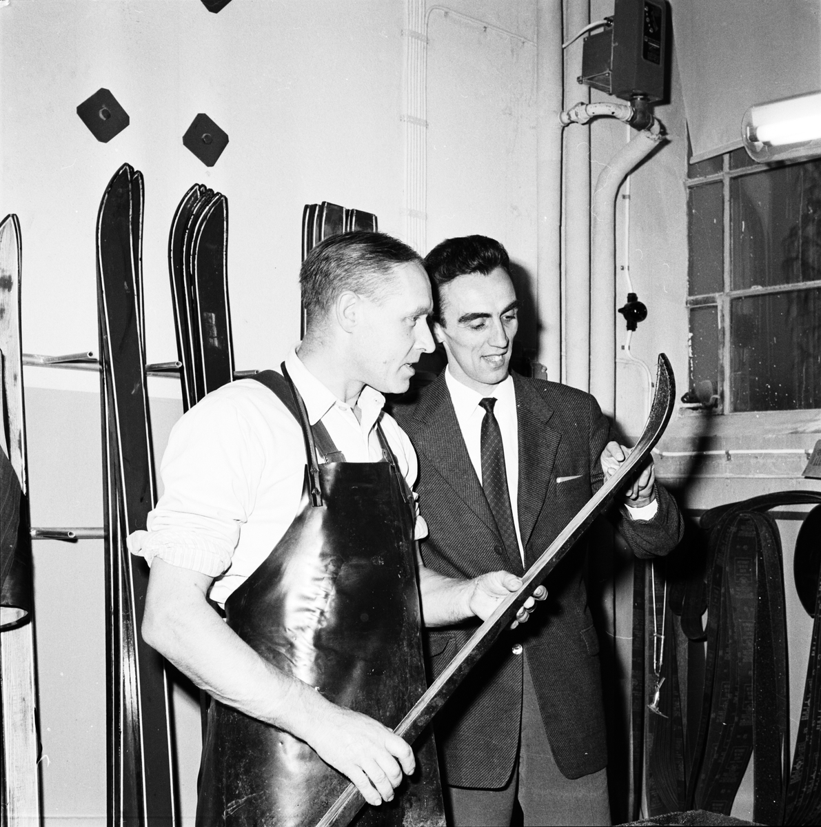Före detta utförsåkaren Stig Sollander tittar på tillverkningen av skidor, Tobo bruk, Uppland 1959