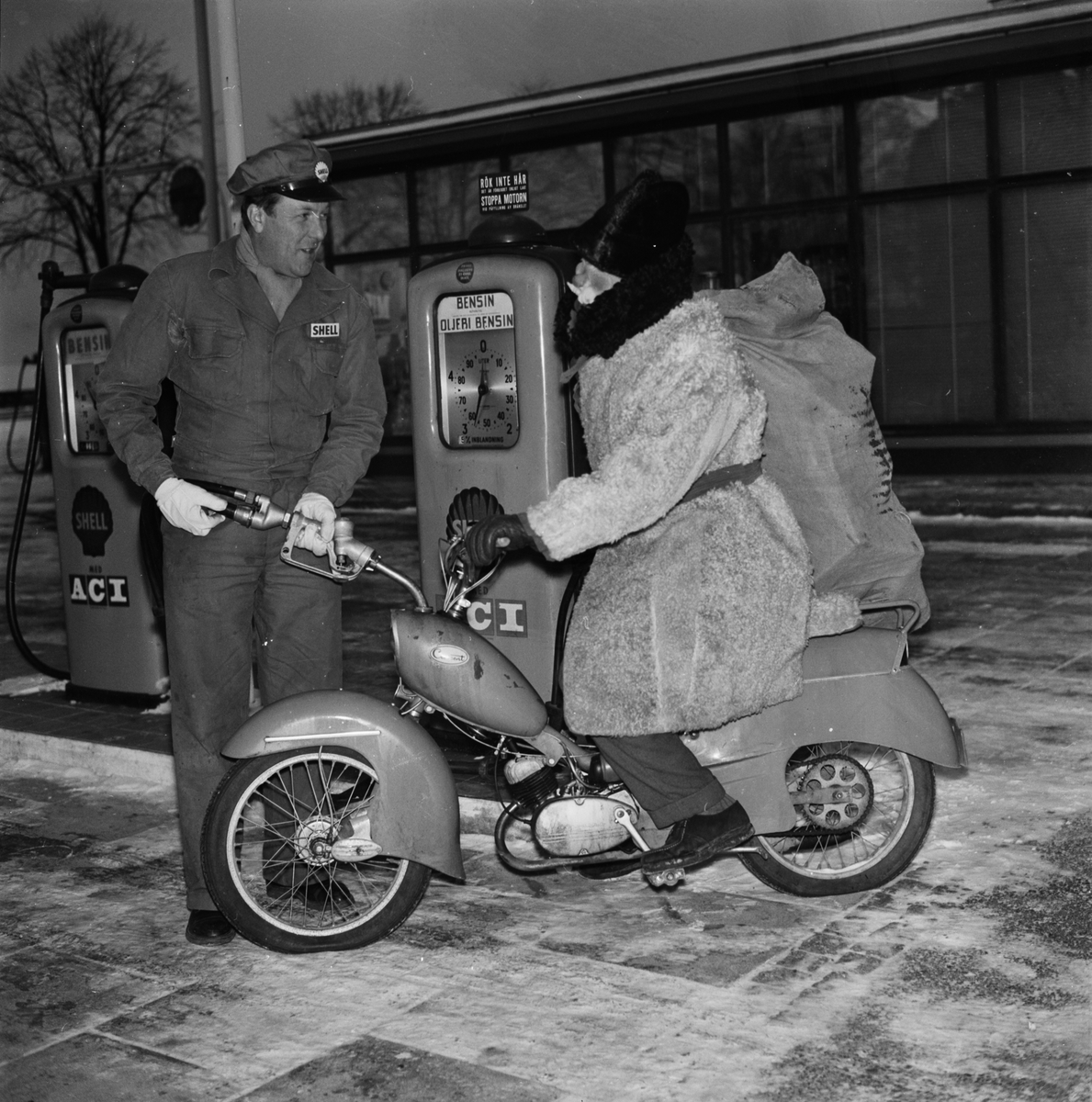 "Upsalaborna rustar till julen" - en förutseende tomte tankar sin moped hos R Kersel, Vaksalagatan 85, Uppsala 1957