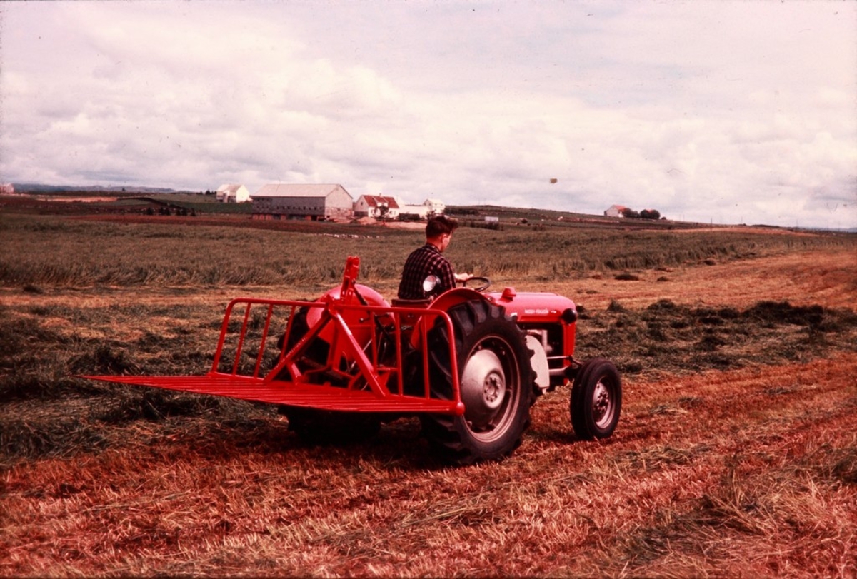 Silosvans fra Kvernelands Fabrikk AS, bakmontert på traktor, ute på en eng på Jæren