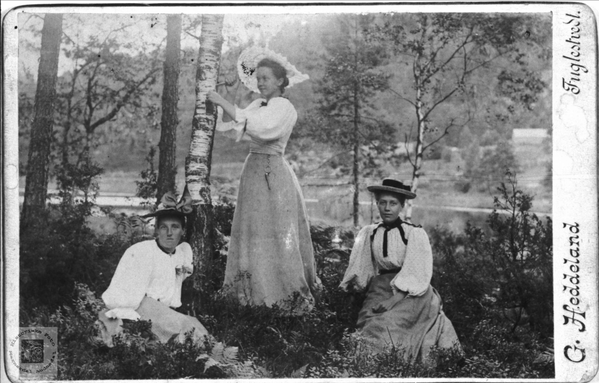 Portrett av 3 ukjente damer fotografert av lokalfotograf. G. Heddeland.