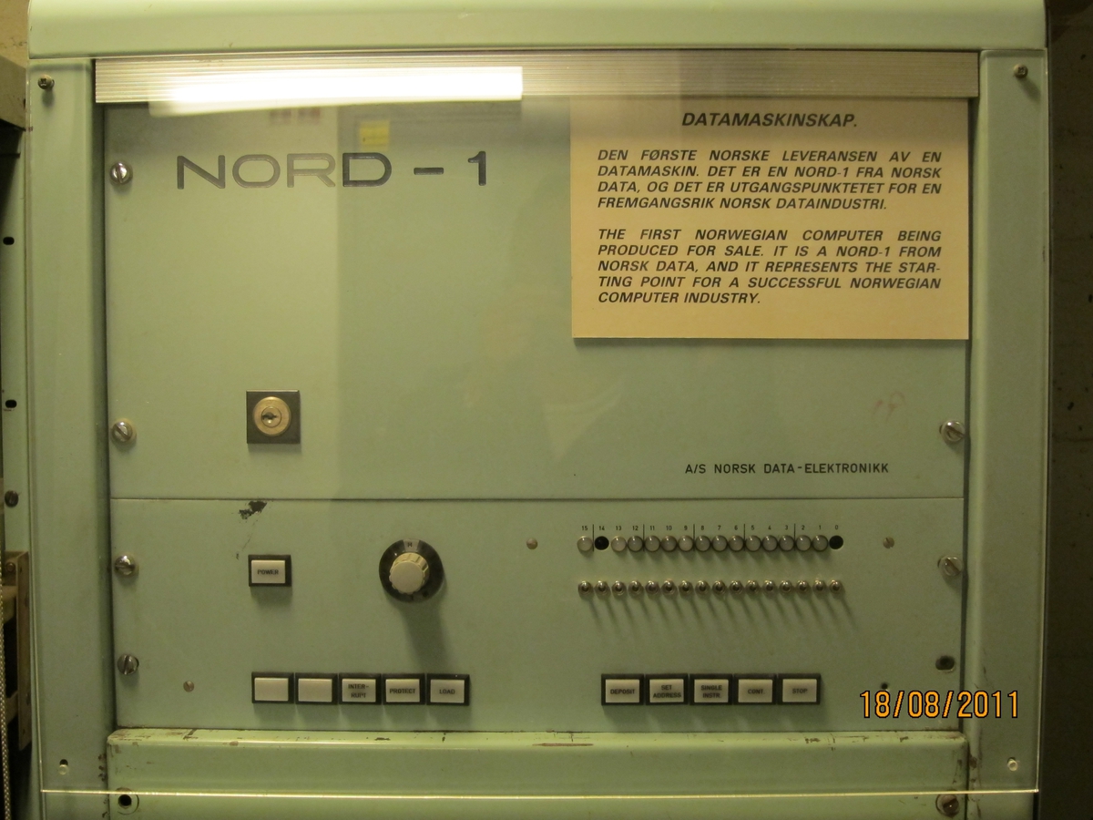 Pult med radarskjerm, brytere og display for 'miles',  'degrees north' og 'minutes'. Pult mrk. A, 3 skap mrk. B, C og D. Pulten og 5 skap sto ombord i 'Taimyr', Wilhelm Wilhelmsen´s rederi. (NSM 13028) Prosjektet startet i 1967, finansiert ved hjelp av midler fra  Norges Teknisk-naturvidenskapelige Forskningsråd. 26. januar 1968 ble kontrakt undertegnet med Norsk Data og anlegget ble satt i drift i 1969. Det har hatt stor betydning for utviklingen og var verdens første. Dette er forløperen til Norcontrol´s databridge som i 1981 var installert på 210 skip.