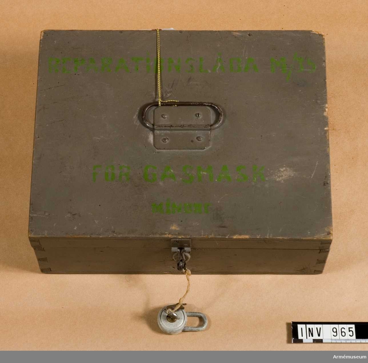 Reparationslåda m/1935 t gasmask.
Innehåller diverse reservdelar för gasmask. Samtliga verktyg saknas. Tillv. av gråmålat trä.
