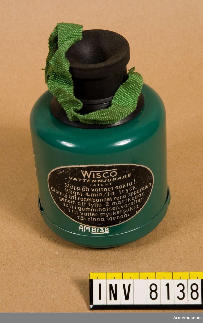 Vattenmjukare Wisco.Tillverkad av grön och svart plåt och gummi. Klistrad etikett  "Wisco vattenmjukare Patent". I botten med vit oljefärg "C". Apparaten skall sättas på en vattenkran. Vattnet får rinna igenom med högst 4 min/liter (sic!) tryck. Rening av apparaten görs med 2 matskedar salt som läggs i gummivalsen varefter en liter vatten sakta får rinna igenom. Bruksanvisning finns i förpackningen.Ingår i fotomaterielsats 7 låda 2.