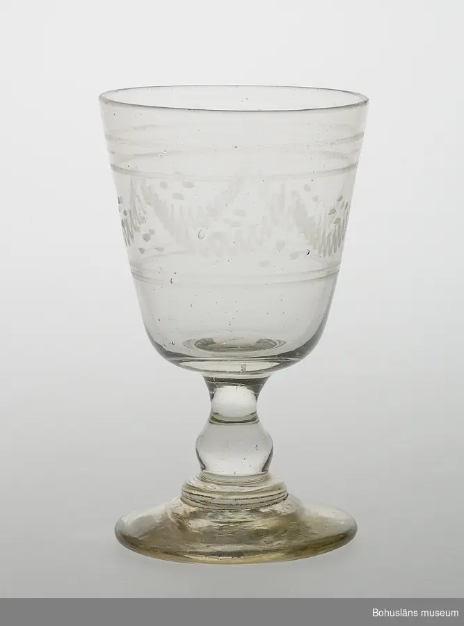 Ur handskrivna katalogen 1957-1958:
Ölglas, handetsat
Mynningsdiam.: 8,2. H: 13,8. Skål med vit dekor, lågt skaft, rund fot. Hel.