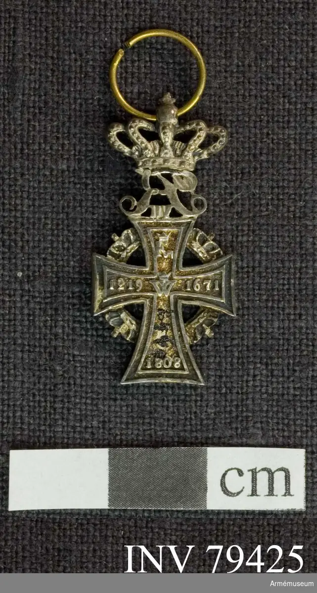 Grupp M.

Åtsida: Ett silverkors med inskriptionen (i upphöjda bokstäver) lika fördelad på korsets armar. Högst upp R VII. Jämsides med ytterlinien löper en smal, upphöjd rand, i mitten "C5" under kunglig krona. 

Mellan korsets armar äro placerade kungliga kronor i en cirkel; ovanpå äversta armen "R VIII" under kunglig krona.

Frånsidan: Samma utseende som åtsidan utom att "R VII" står bakfram och inskriptionen är en annan.

På korsets översta arm "F VI" under kunglig krona, på venstra armen: 1219, på högra armen 1671 och på den nedersta 1808, i korsets mitt: W under en krona.

Beskrivning: Carl Peyron.