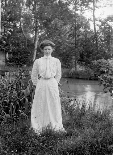 En kvinna står framför dammen bredvid Torreby slott