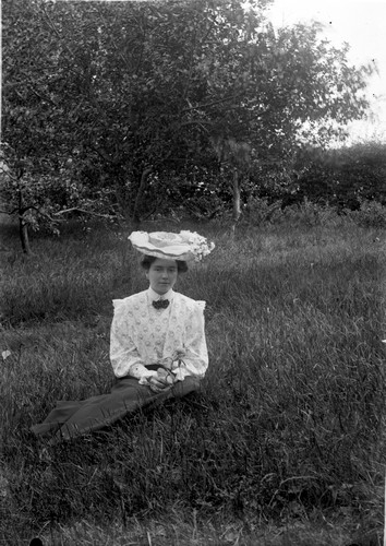 Kvinna som sitter i gräset, förmodligen på Torreby