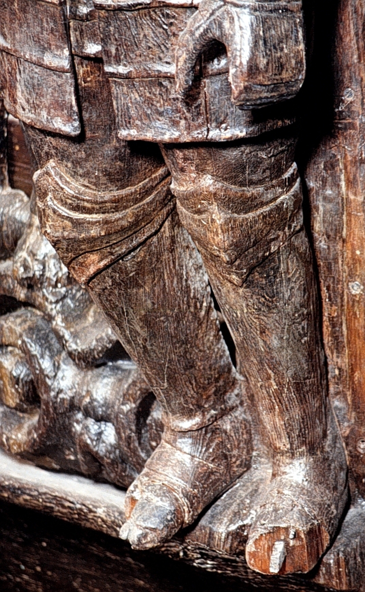 Skulptur av riddare i 1600-talsrustning.
Skulpturen återger en skägglös krigare i full mundering, med rikt plymförsedd hjälm med uppfällt visir. Horisontellt över bröstets övre del är en fältbindel draperad. Kring midjan är spänt ett smalt läderimiterande bälte. Rustningen är i övrigt stiltrogen med sitt korta bröstharnesk med ansats till så kallad tapul, det vill säga den spetsformiga utbuktningen strax under bröstets mittpunkt, sina långa, mot knäna neddragna lårskört samt knä- och armbågsskydd. Troligtvis har riddaren varit utrustad med svärd eller lans, kanske också sköld.

Huvudet är vridet åt höger och vänster arm hålls något krökt utefter kroppssidan. Höger arm saknas. Kroppstyngden förefaller någorlunda jämnt fördelad på båda benen, men höger ben är något böjt. Fötternas främre del saknas men har ursprungligen gått utanför sockelns framkant.

Skulpturen är snidad i ett stycke så när som på armar och höftparti som är utförda separat och fastsatta med dymlingar och spikar. Även fötternas ytterändar har varit separat snidade. Baksidan är slät. Upptill är bakstycket snett uppdraget ovanför skulpturens huvud och bildar en kraftig huvudplatta. Fotändan snedskuren.
Skulpturen är mycket välbevarad, bortsett från den saknade högerarmen och skador på fötterna.

Text in English: Sculpture of a knight in seventeenth-century armour, clean-shaven.
Around the man''s waist is a thin belt, simulating leather. Otherwise the armour is faithful to the contemporary style, with its short cuirass and breastplate tapered to a point and long tuille, and cubitieres and knee pieces. The field badge is draped horizontally round his neck. The head is turned to the left and the left arm is held slightly bent at the side. The right arm is missing. The weight of the body seems more or less evenly distributed over both legs but the right leg is slightly bent. The toes of his feet are missing but would have protruded over the edge of the base.
The sculpture is extremely well-preserved, apart from the missing right arm and the damage to the feet.