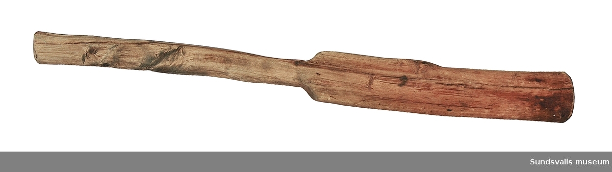 SuM 5629:1-3 korvspruta med tillhörande korvhorn och påpetare. Korvsprutan i gjutjärn sitter fastmonterad på en träplatta försedd med ett handtag. Det finns rester av rödbrun färg. Korvhornet är tillverkat i metall och är 16 cm långt. Påpetaren är snidad i trä och mäter 43 cm.