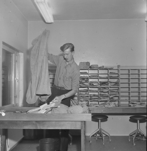 Fotografier av Hans Pehrsson, Solna.  Foton 1956-11.  Brevbärare
Karl Rune Wikström sorterar post på postexpeditionen Barkarby.