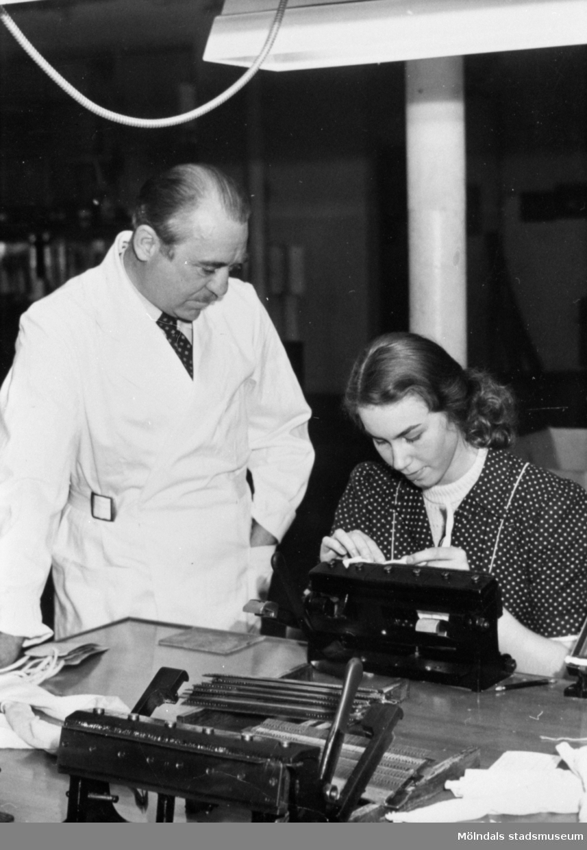 Kaj Larsson granskar en stickerska i arbete på Viktor Samuelsons fabrik "Strumpan", cirka 1940.
