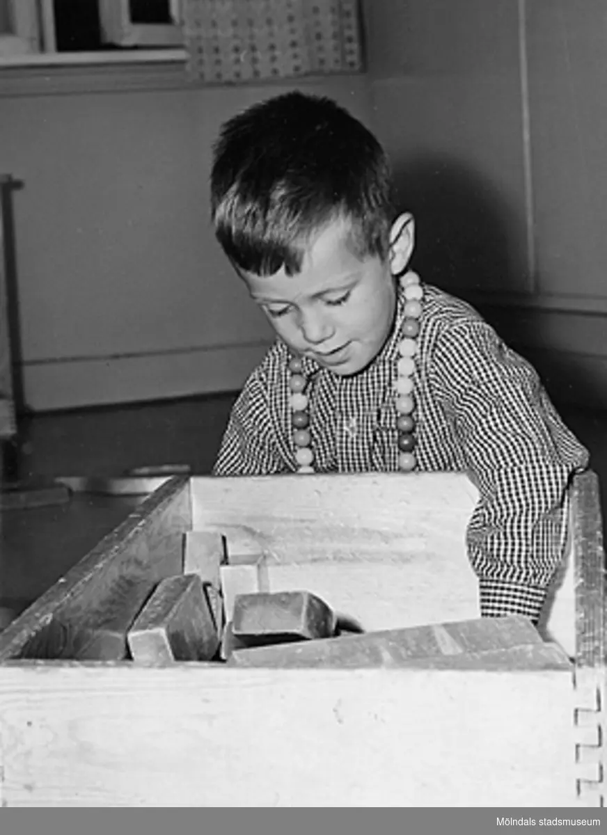 En pojke som leker med träklossar vid Holtermanska daghemmet 1953.