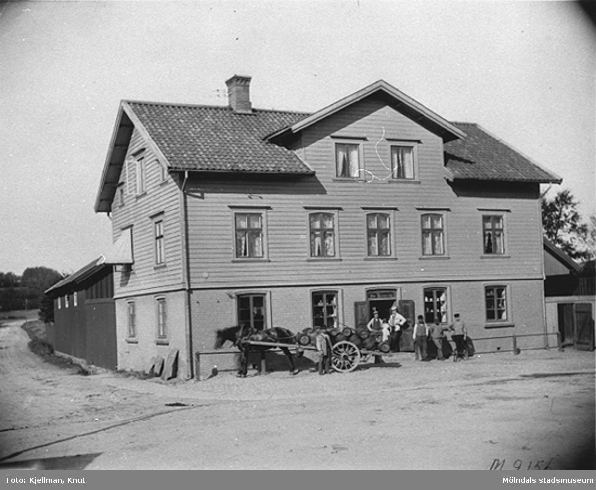 Nymanska huset vid Mölndalsbro (Nymans hus på Göteborgsvägen), 1910-tal. Huset revs 1937. Emiliedals bryggeri lastar av svagdricka.