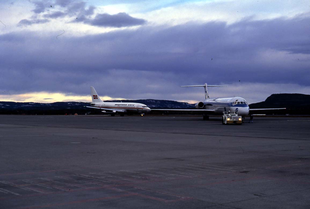 Lufthavn. 1 fly på bakken. 1 McDonnell Douglas MD-82 OH-LMO fra Finnair, sett forfra. 1 Boeing 737 fra Braathens og åser i bakgrunen.