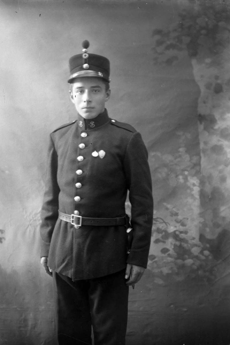 Studioportrett i halvfigur av en ung mann i uniform.