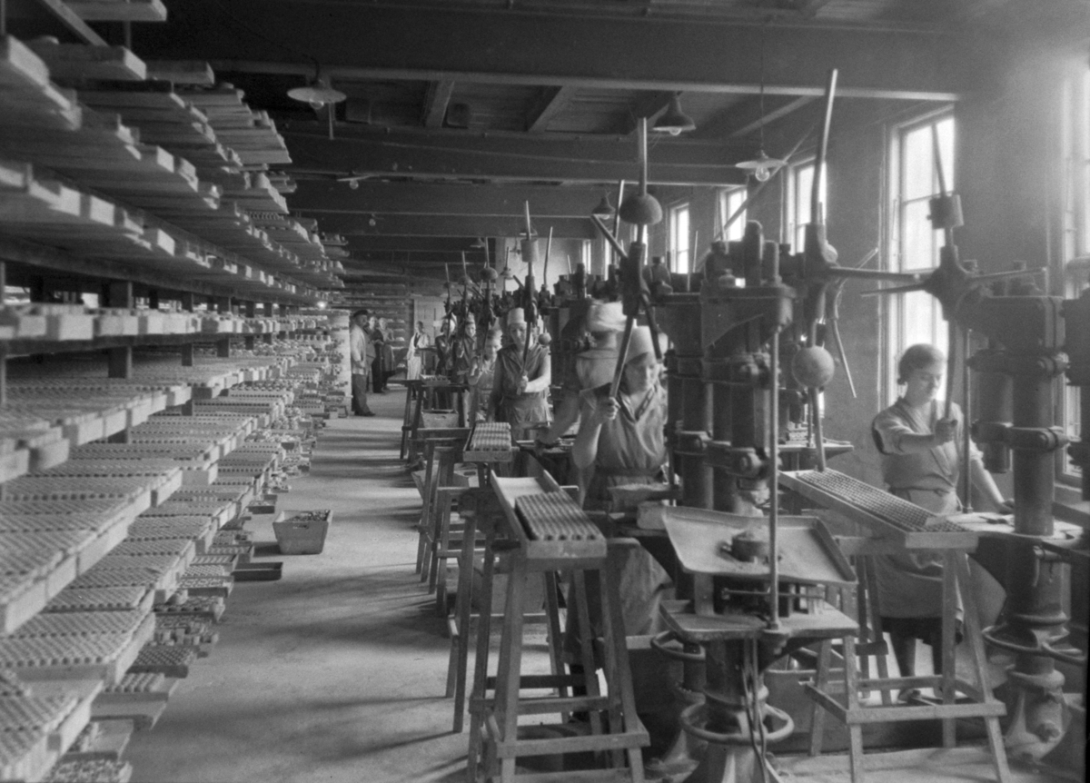 Kvinner i arbeid ved maskiner ved Norsk Teknisk Porslensfabrikk.