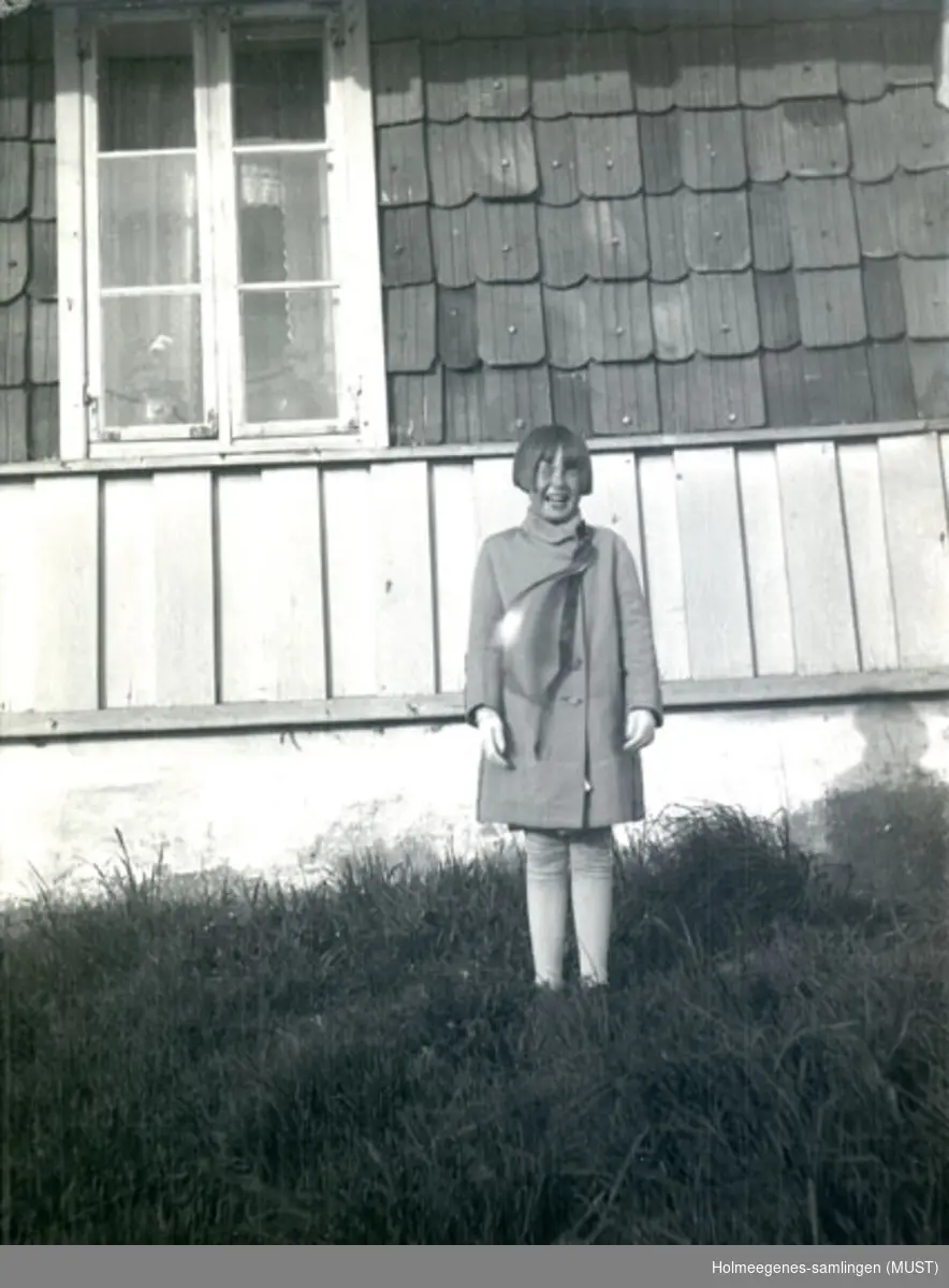 En pike med lang 17.maisløyfe foran huset på Holmeegenes i Stavanger.