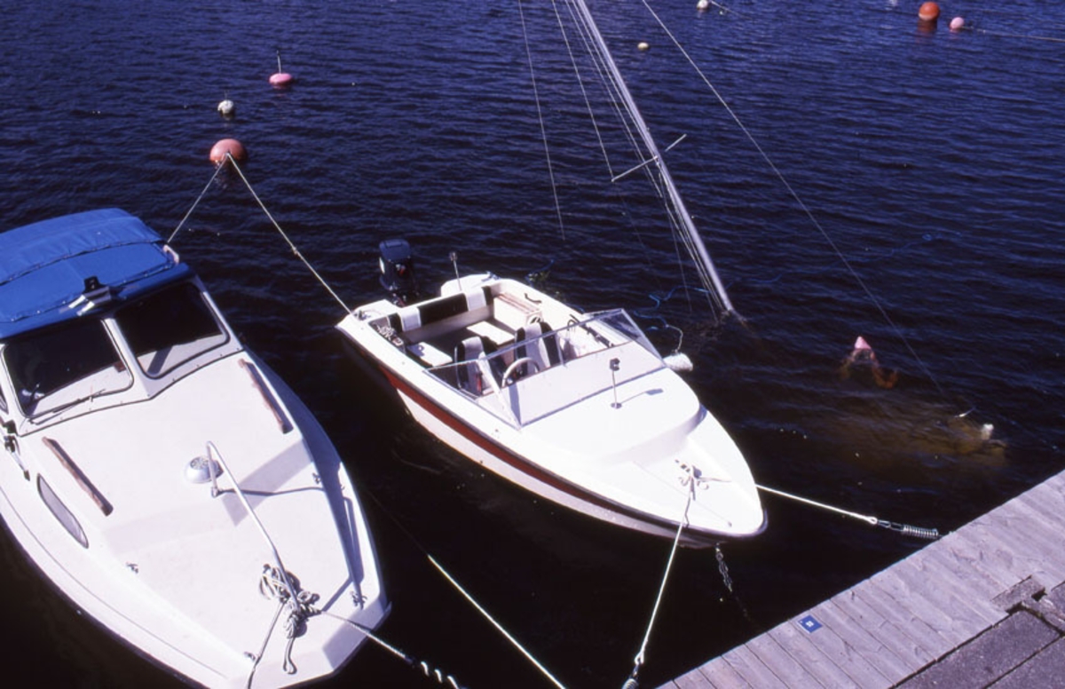 Södermalm. Kabinbåt, möjligen Fisksätra, daycruiser liknande Flipper samt sjunken segelbåt.