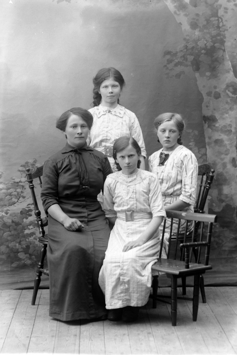 Studioportrett av en kvinne med tre unge jenter.
