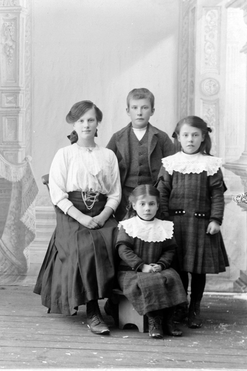 Studioportrett av en ung pike med tre barn.