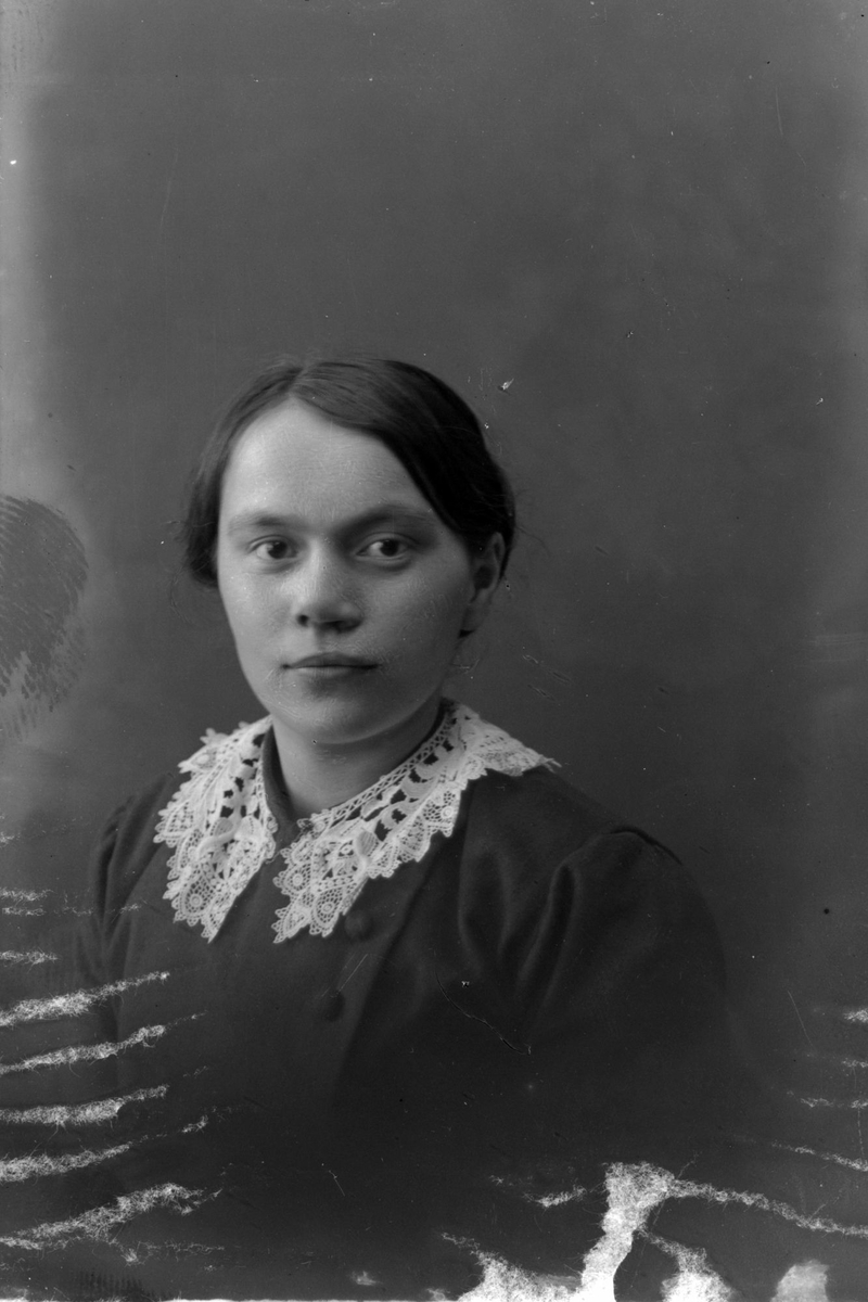Studioportrett i halvfigur av en kvinne.