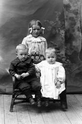 Studioportrett av tre barn i helfigur.