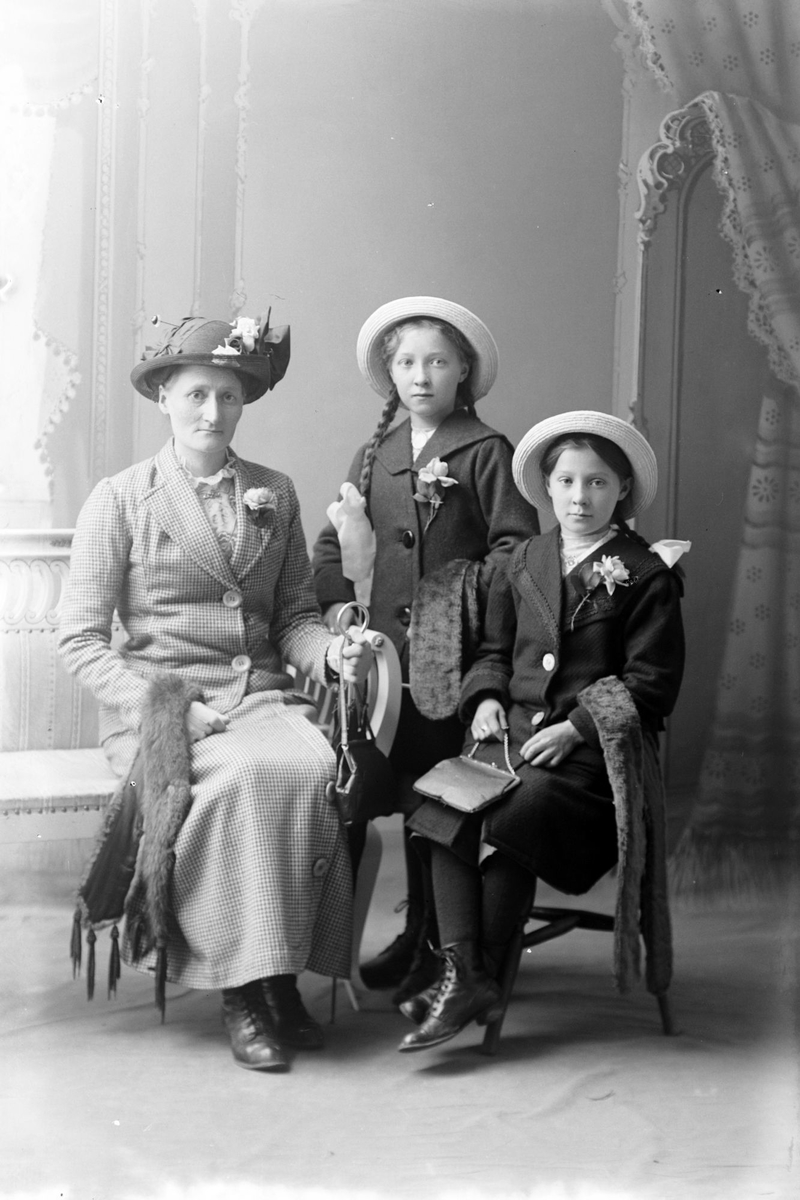 Studioportrett av en kvinne med to unge piker.