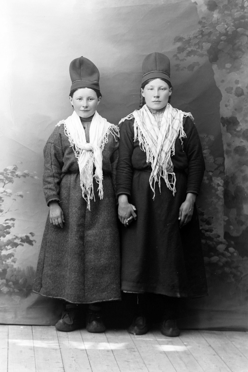 Studioportrett av to kvinner med samiske hodeplagg.