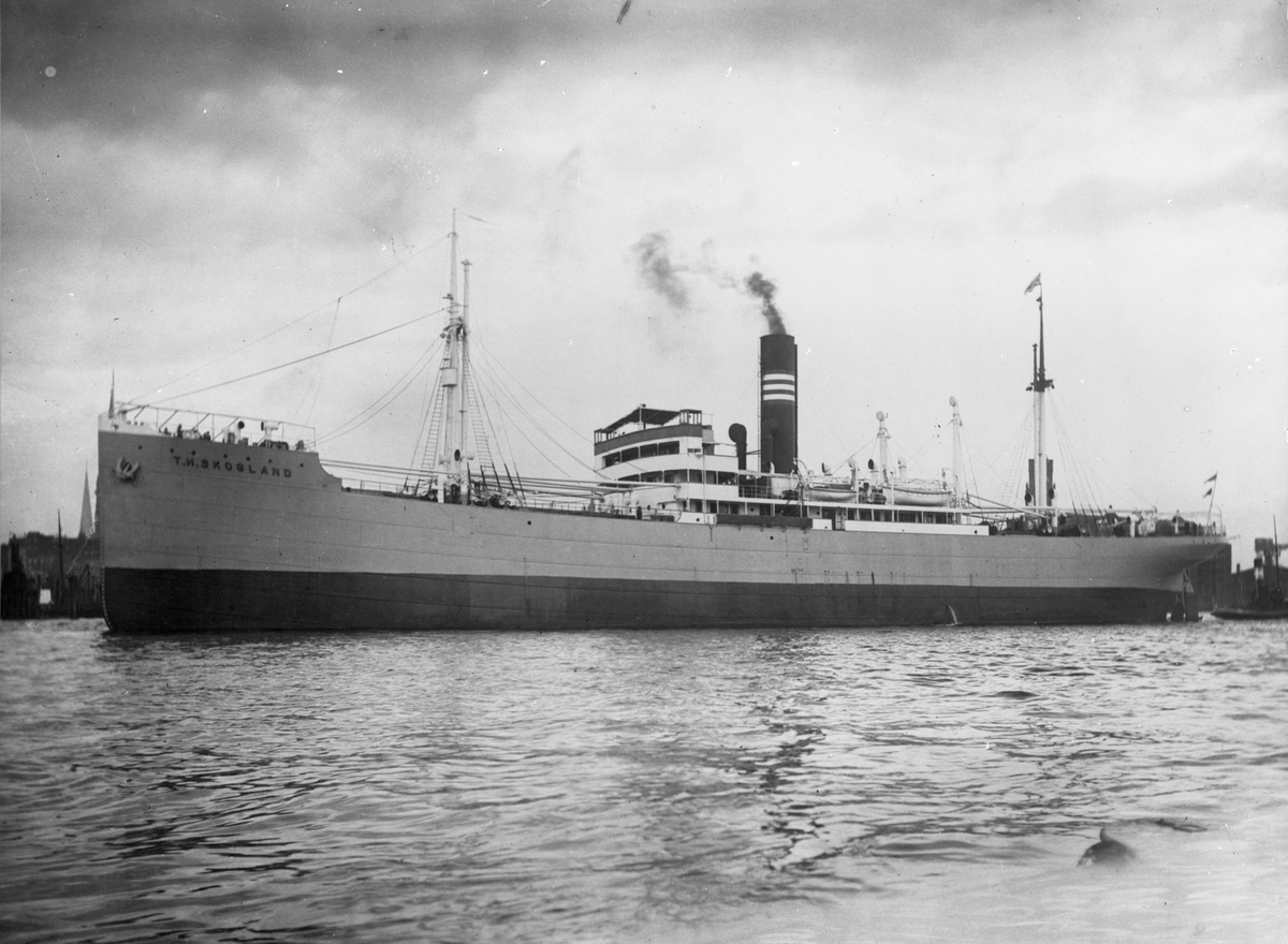 Dampskipet D/S "T. H. Skogland" ankret opp ved en by. Gikk i linjefart mellom Nord-Europa og Sør-Amerika.