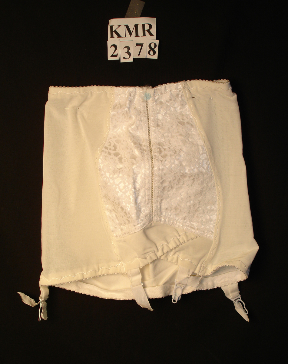 Hofteholder, undertøy i elastisk stoff med blondepynt i fronten, fire hemper i strikk til å feste strømper med.
