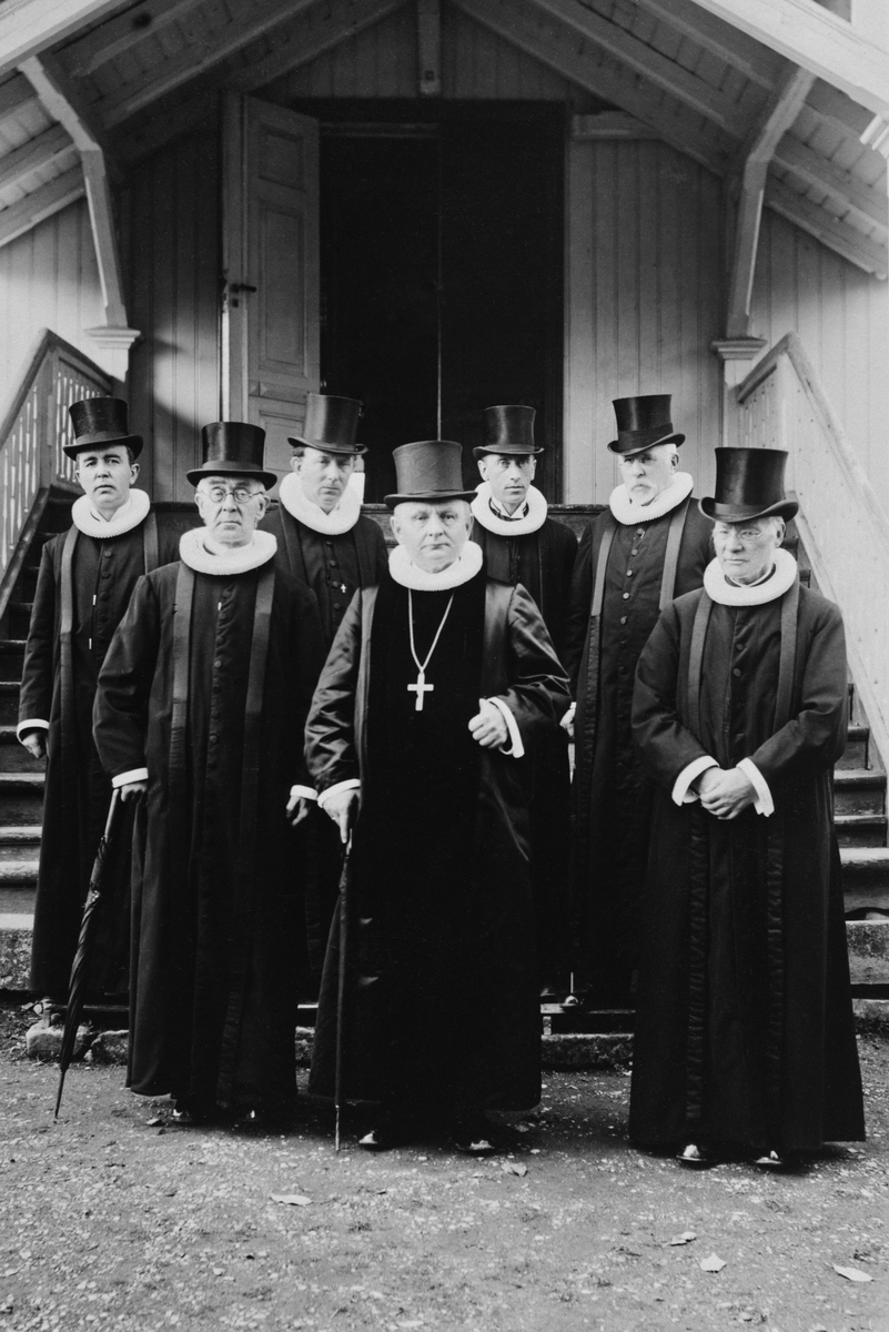 Gruppe 7 prester i flosshatter,prestekjole,Veldre kirke. T.h pastor Reinert Svendsen, nr. 2 f.h fremst biskop Johan Lunde. De øvrige ukjente. 200års-jubileum 1926.
