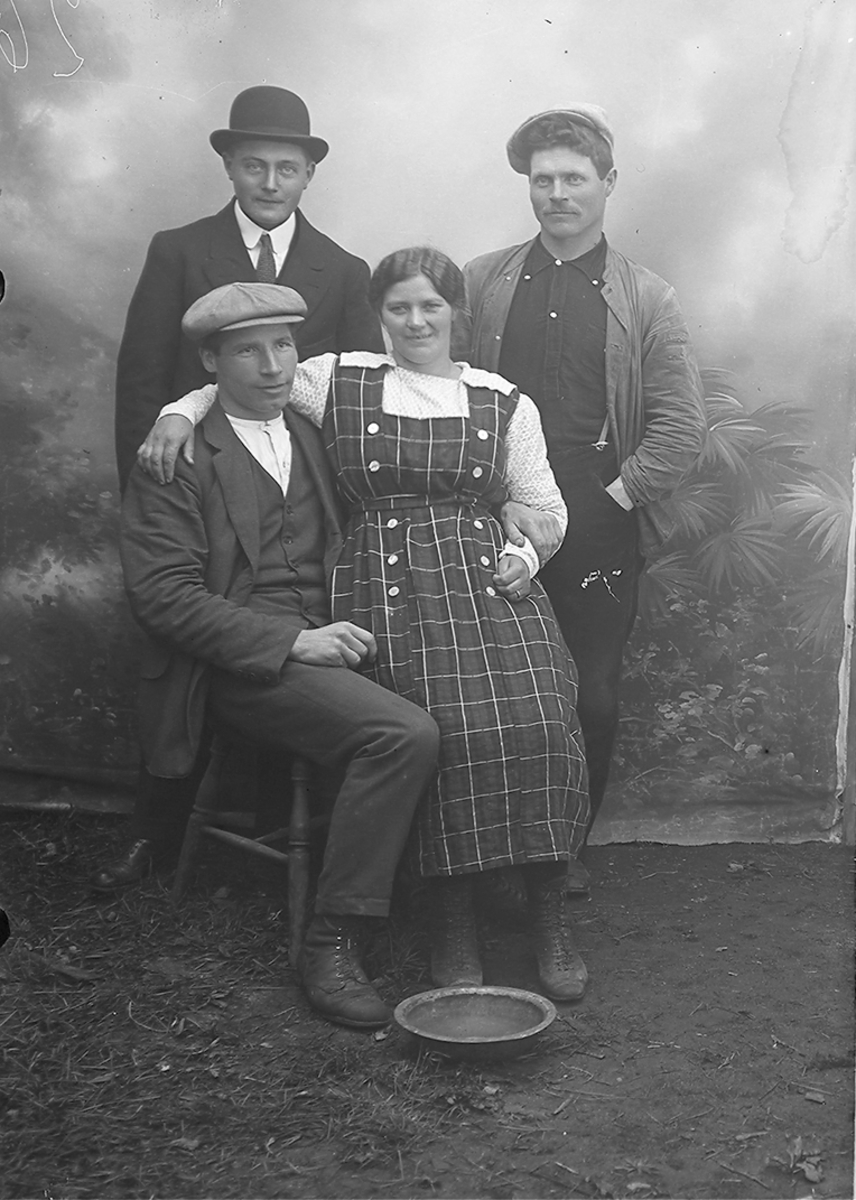 Portrett. En kvinne og 3 menn i 30-40-åra. Kvinnen sitter på fanget til en av mennene. De 2 andre mennene står bak.Bildet er tatt i Sørfold.