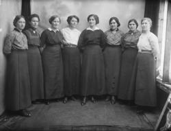 Gruppebilde. 8 kvinner i 30-40-åra. Alle står.