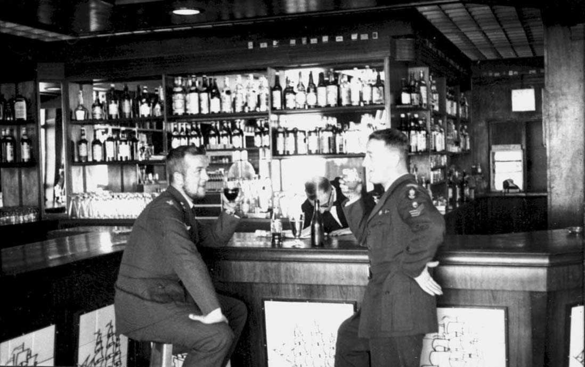 By. To personer, menn i militæruniform, inne i en restaurant.