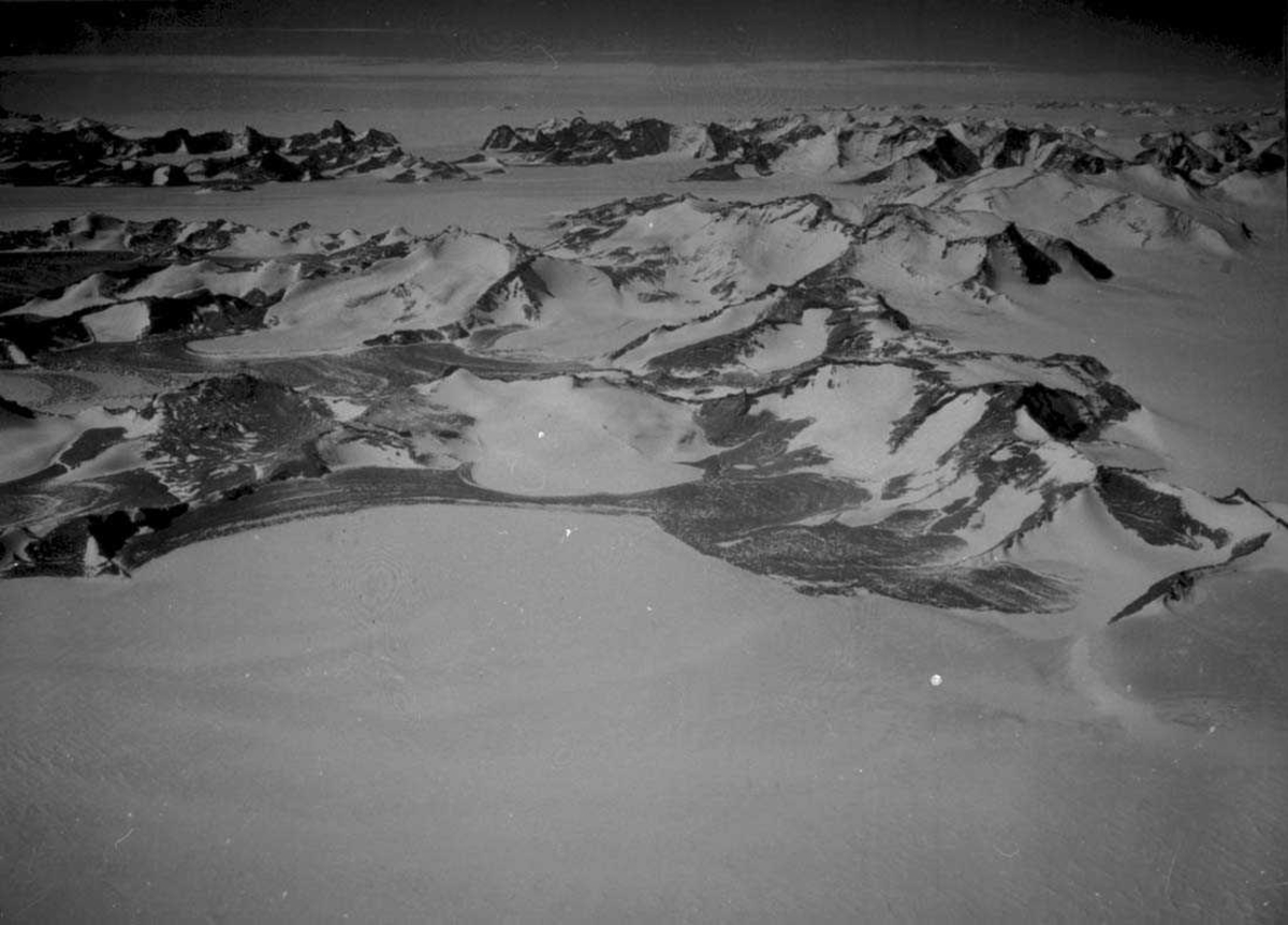 Luftfoto. Snødekt landskap med fjelltopper.
