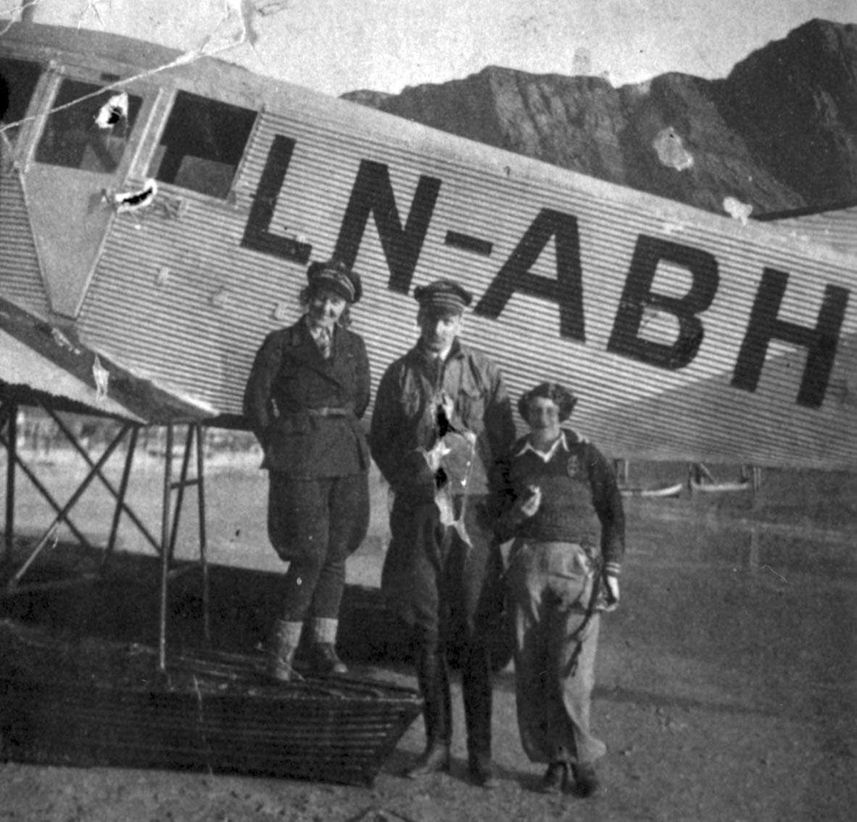 Ett fly ved strandkanten, Junkers F.13W. I 1932 omregistrert til LN-ABH og solgt til Nord -Norges Aero A/S, Narvik. Tre personer, en kvinne og to menn, oppstilt ved flyet