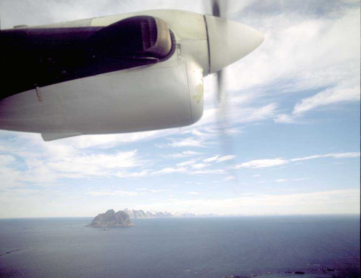 Luftfoto. Etter avgang Værøy. Panorama fra sidevinduet i DHC-6-300 Twin Otter fra Widerøe. Nærmest ses øya Mosken deretter Lofotfjellene som forsvinner i havet i nordøst.